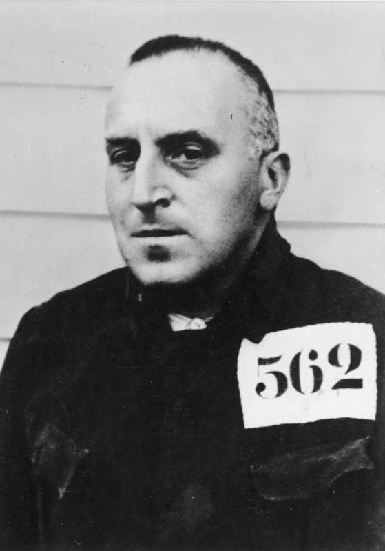 Black and white photo of Carl von Ossietzky in prison clothes, a sign with number 562
