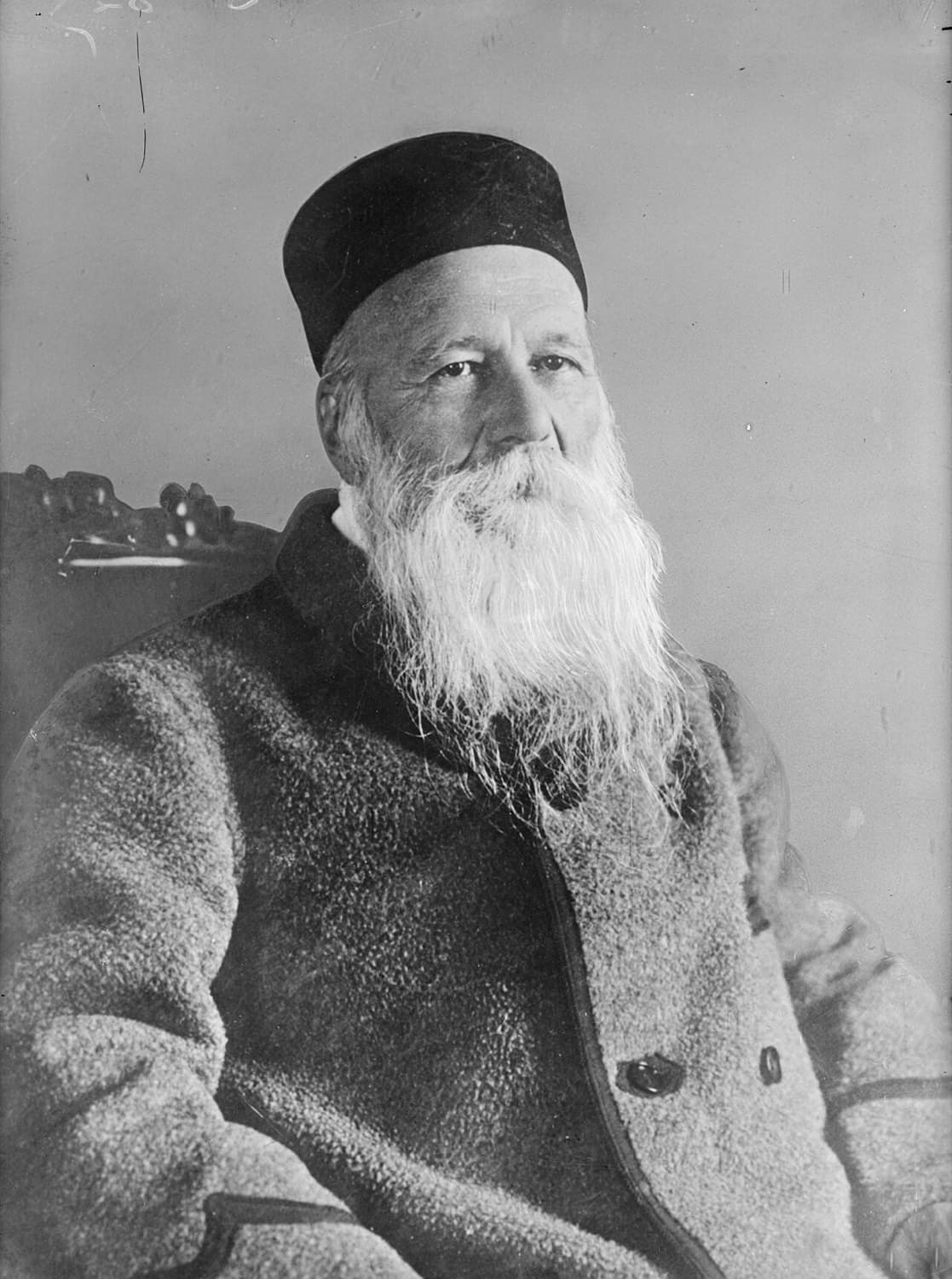 Schwarzweißfoto von Henry Dunant im Alter mit langem weißem Bart und dunkler Kappe